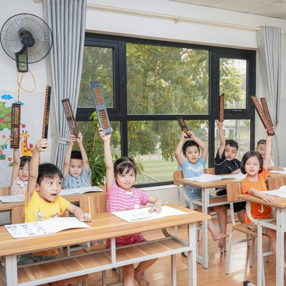 Các bạn nhỏ giơ bàn tính lên trong lớp
