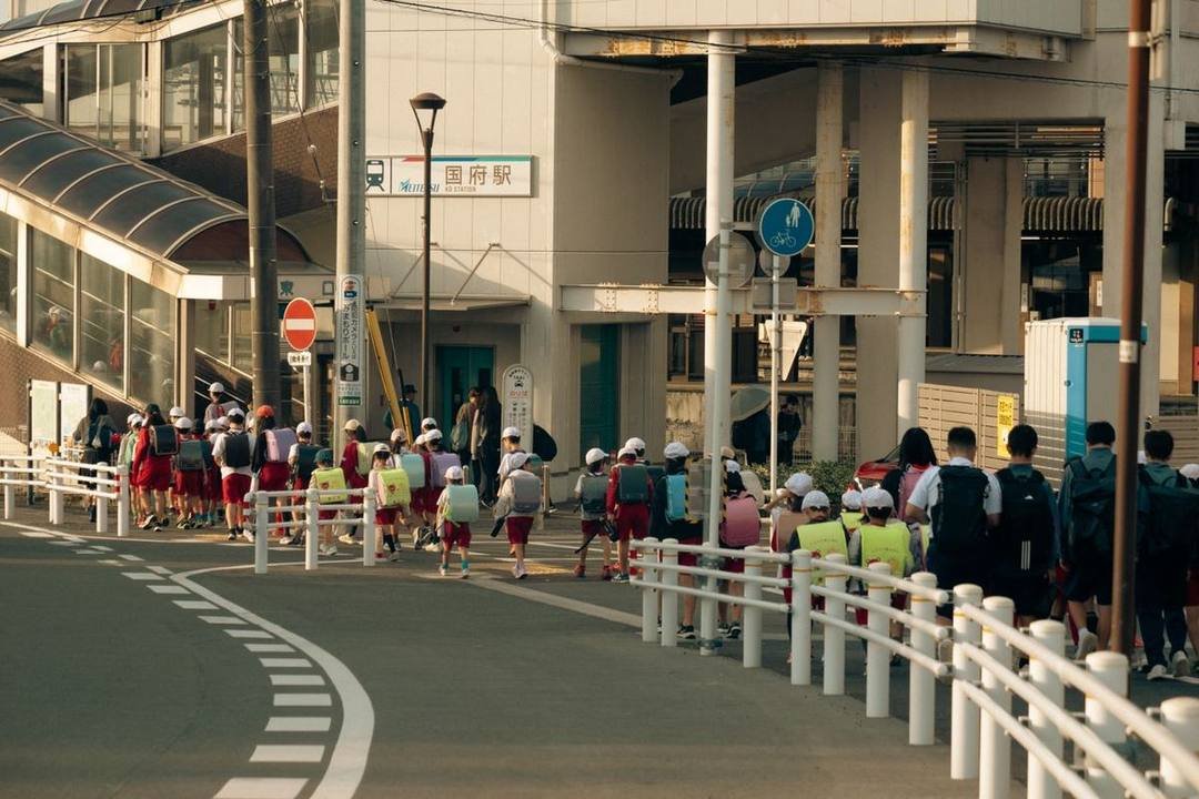 豊川市（愛知県）で、ランドセルに黄色い帽子で列になって歩く小学生