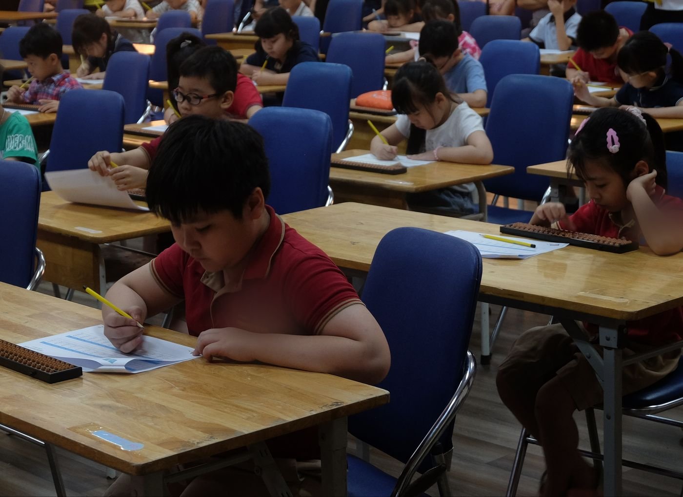 Các bạn nhỏ làm bài thi tính nhẩm bên bàn tính tại Soroban SmartMath Cup 2025